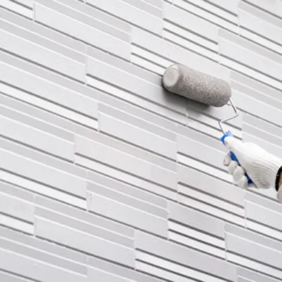 外壁にローラーで塗装を施す施工中の様子