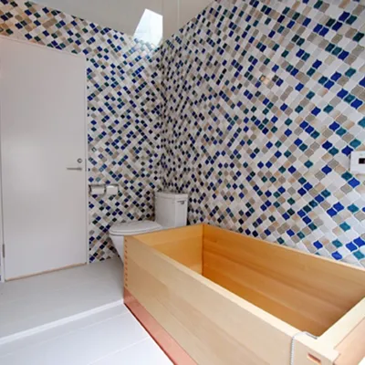 木製浴槽とカラフルなタイル壁のおしゃれな浴室